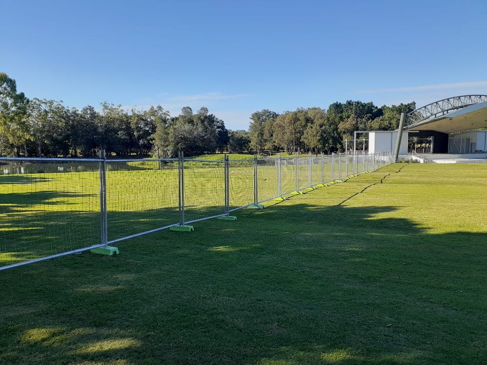 Rent A Fence mesh fencing along a grassed event field under blue sky