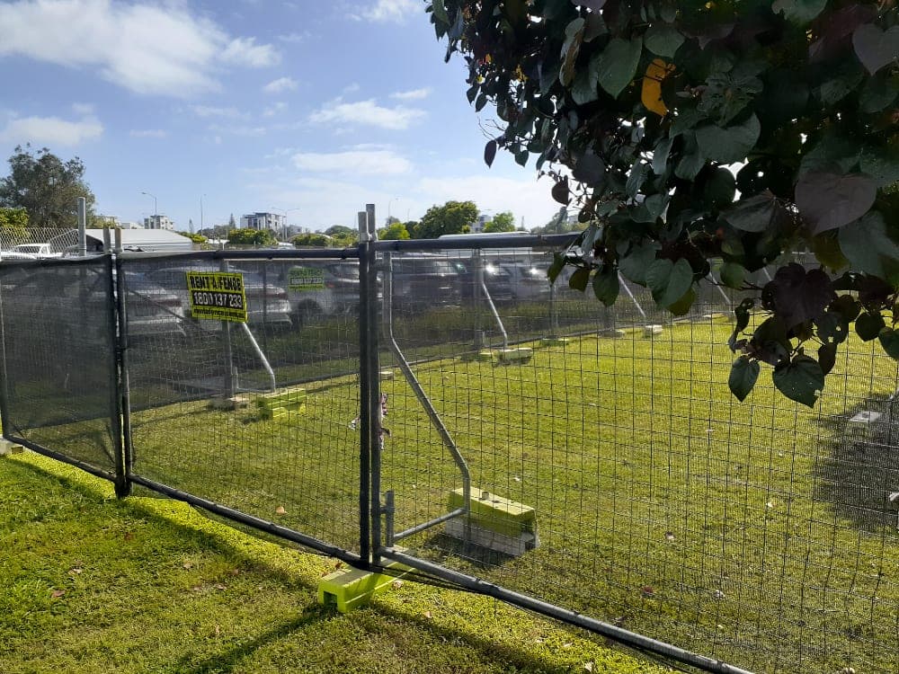 Rent A Fence mesh fencing with a Rent A Fence sign beside a car park