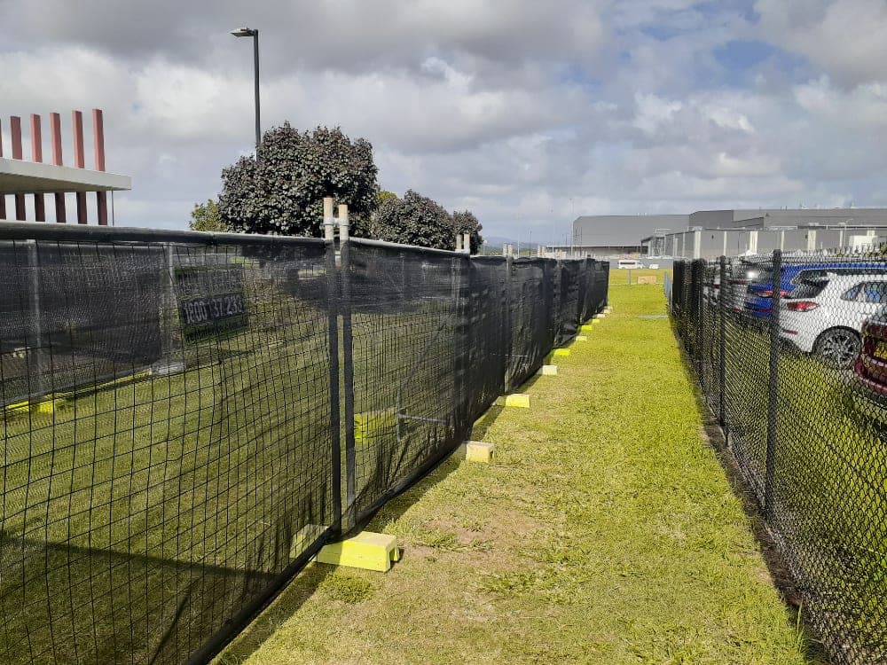 Rent A Fence fencing with black shade cloth along a grassed verge